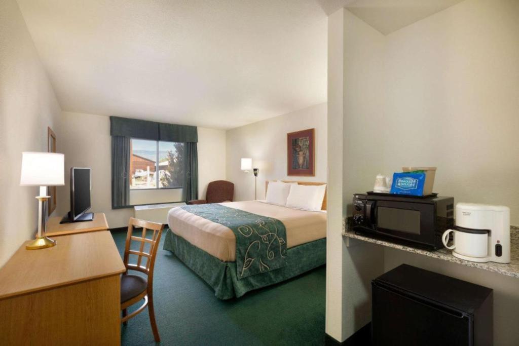 a hotel room with a bed and a desk at Travelodge by Wyndham Yampa in Yampa