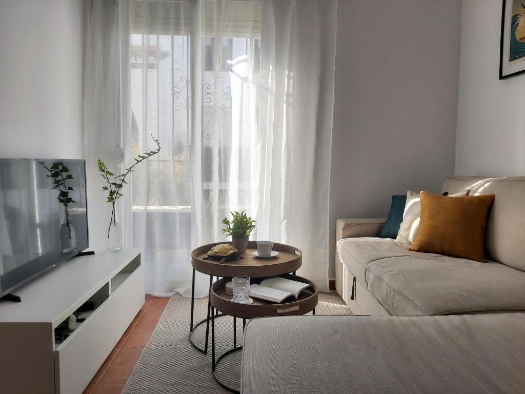 salon z kanapą i stołem w obiekcie Benamara Gardens, Apartment with Pool, 100m from Beach near Marbella & Estepona w mieście Estepona