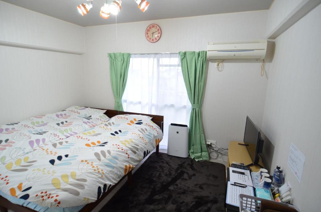 1 dormitorio con 1 cama, TV y ventana en Amont Nakamura - Vacation STAY 83274, en Miyazaki