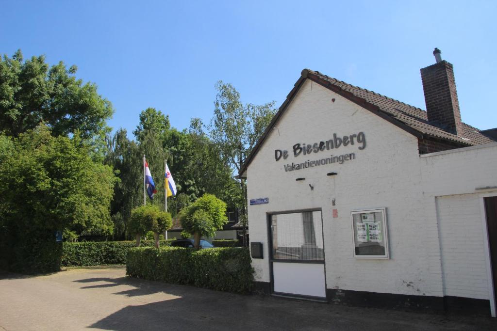 een wit gebouw met een bord aan de zijkant bij De Biesenberg in Ulestraten