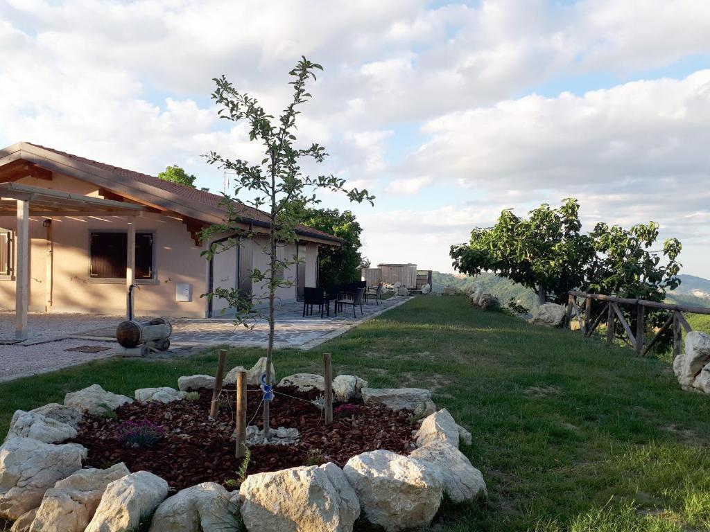un jardín frente a una casa con un árbol en Villa Alba - Colazione Inclusa, en Mercato Saraceno