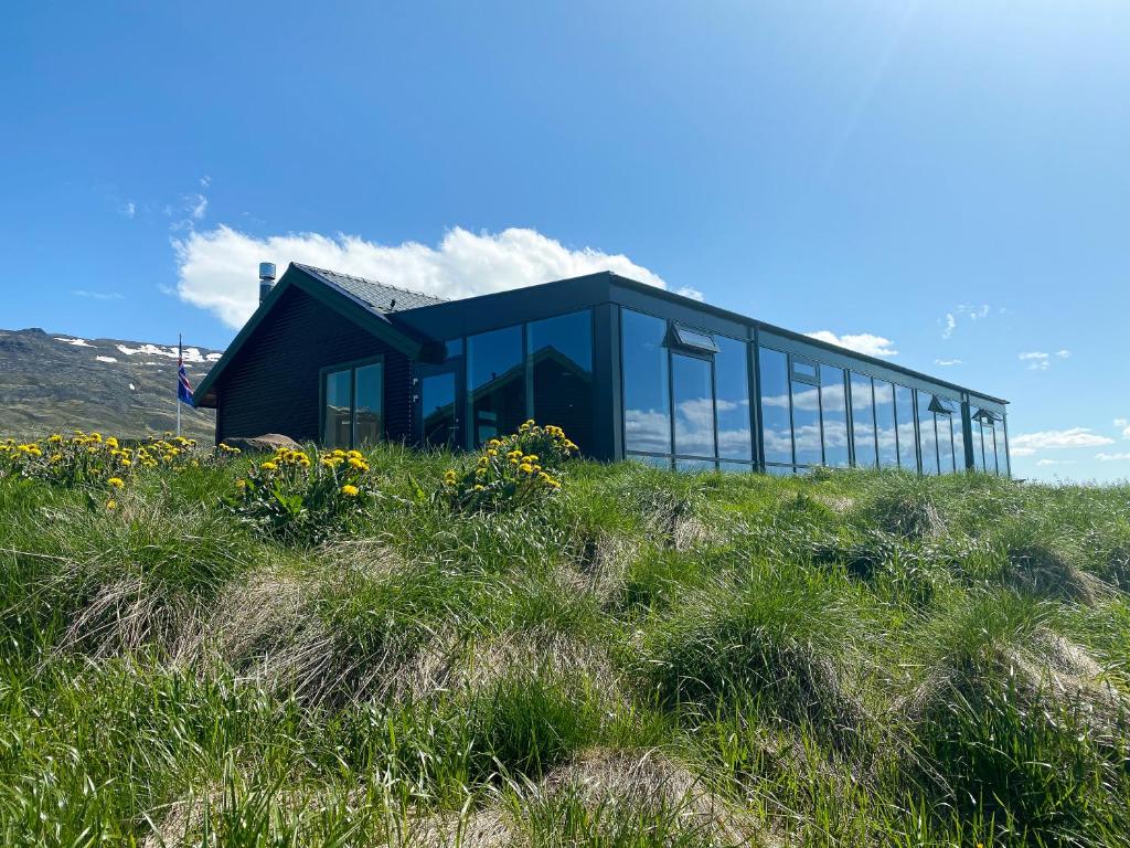 a black house on top of a grassy hill at Hofsstadir - Country Hotel in Hofstaðir