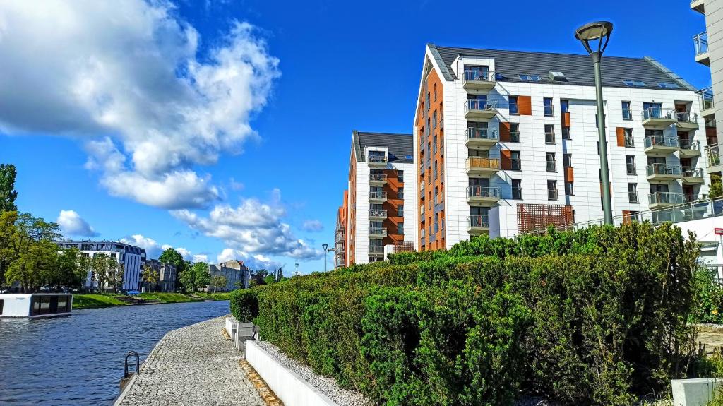 グダニスクにあるStare Miasto Gdansk Jaglana - Comfy Apartmentsの建物と通り灯が隣接する川
