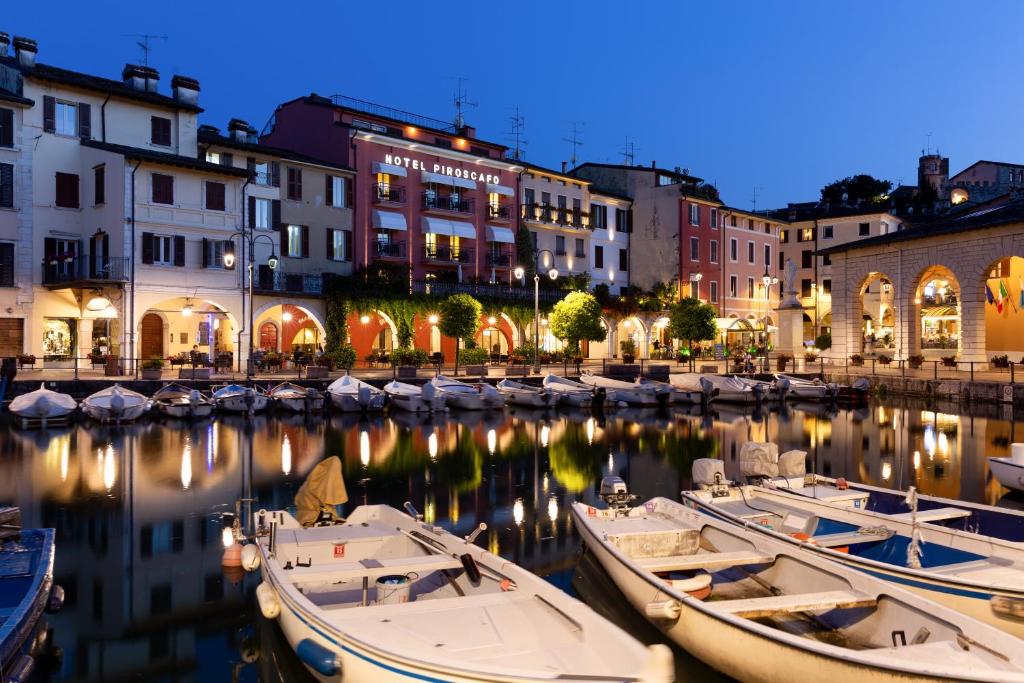 un gruppo di barche ormeggiate in un porto di notte di Hotel Piroscafo a Desenzano del Garda