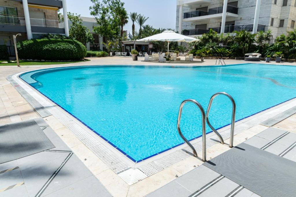 a large blue swimming pool in a building at ROYAL PARK -George in Eilat
