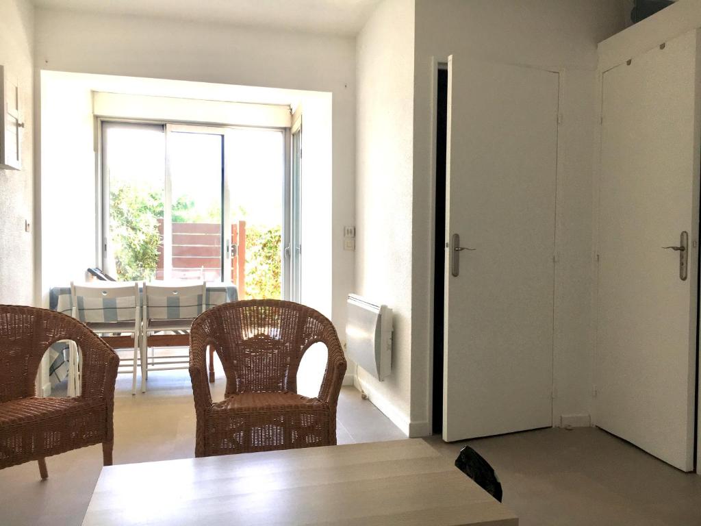 un salon avec deux chaises et une grande fenêtre dans l'établissement Appartement T2 Carnon ouest/Palavas plage, à Palavas-les-Flots