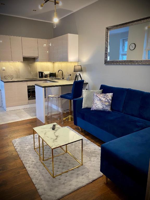 - un salon avec un canapé bleu et une table dans l'établissement Apartament Glamour, à Toruń