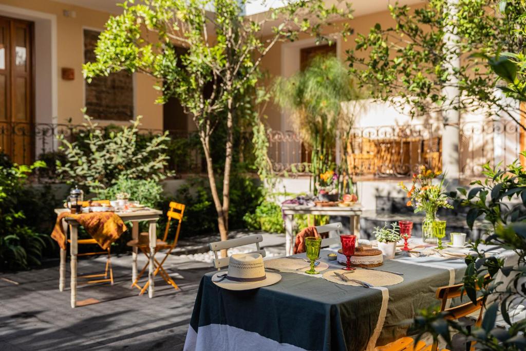 um pátio com mesas, cadeiras e árvores em Casa Tuna em Cidade do México