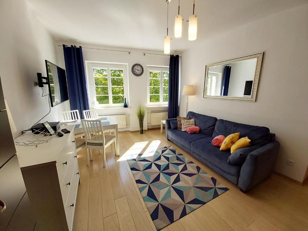ein Wohnzimmer mit einem blauen Sofa und einem Tisch in der Unterkunft Central Apartments Ogarna in Danzig