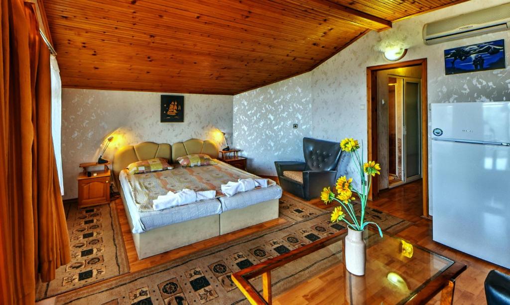 Schlafzimmer mit einem Bett, einem Tisch und einem Kühlschrank in der Unterkunft Villa Summer House in Sweti Konstantin
