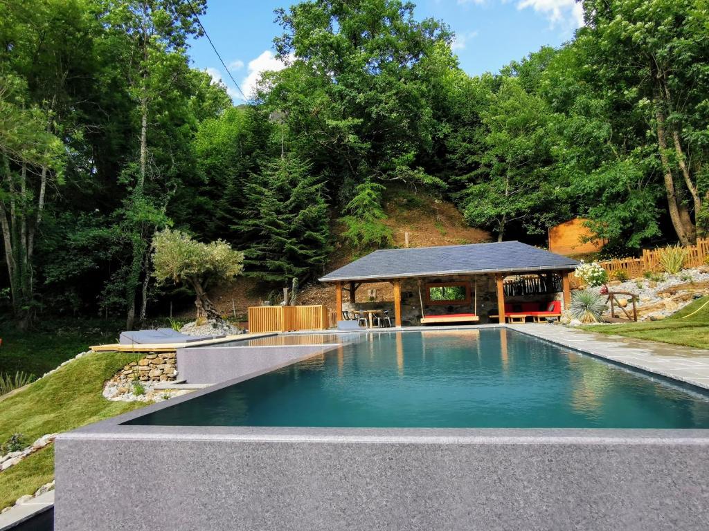 a swimming pool in a garden with a gazebo at La Bergerie de Louvie in Louvie-Soubiron