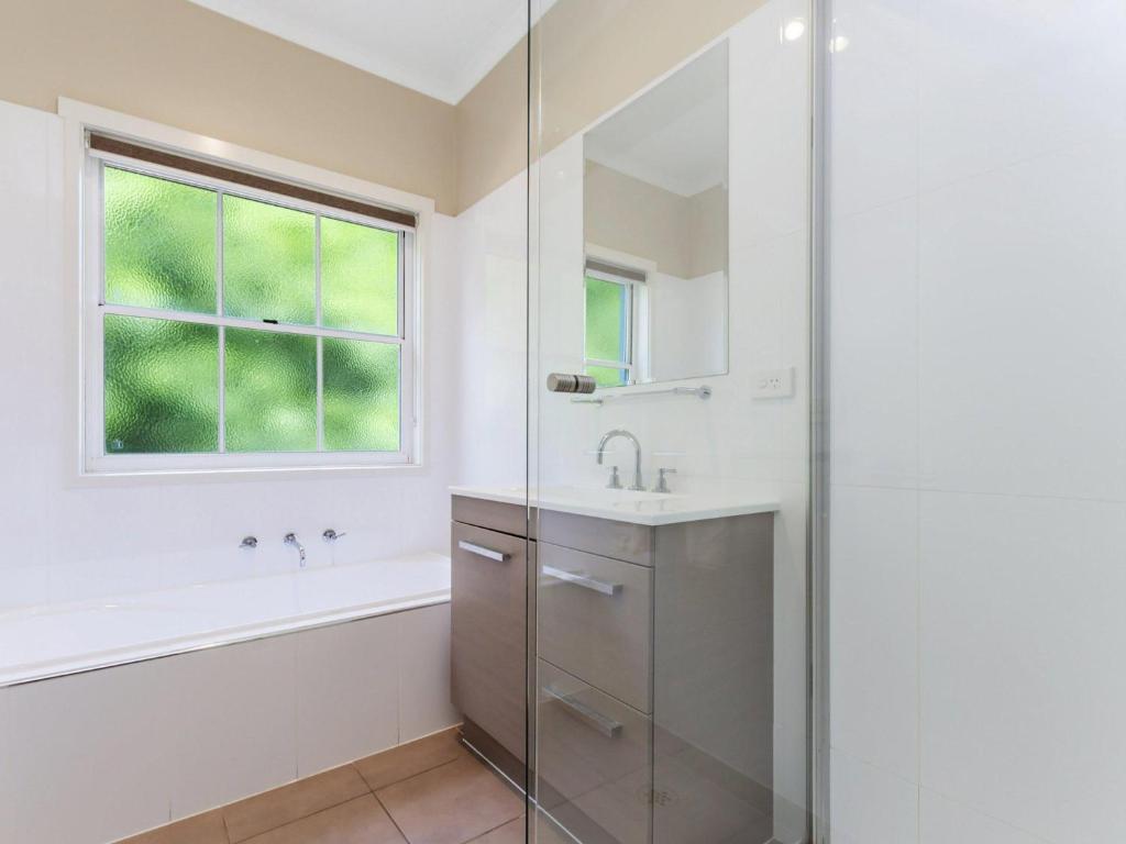 a bathroom with a shower and a sink and a window at Elizas Townhouse in Port Fairy
