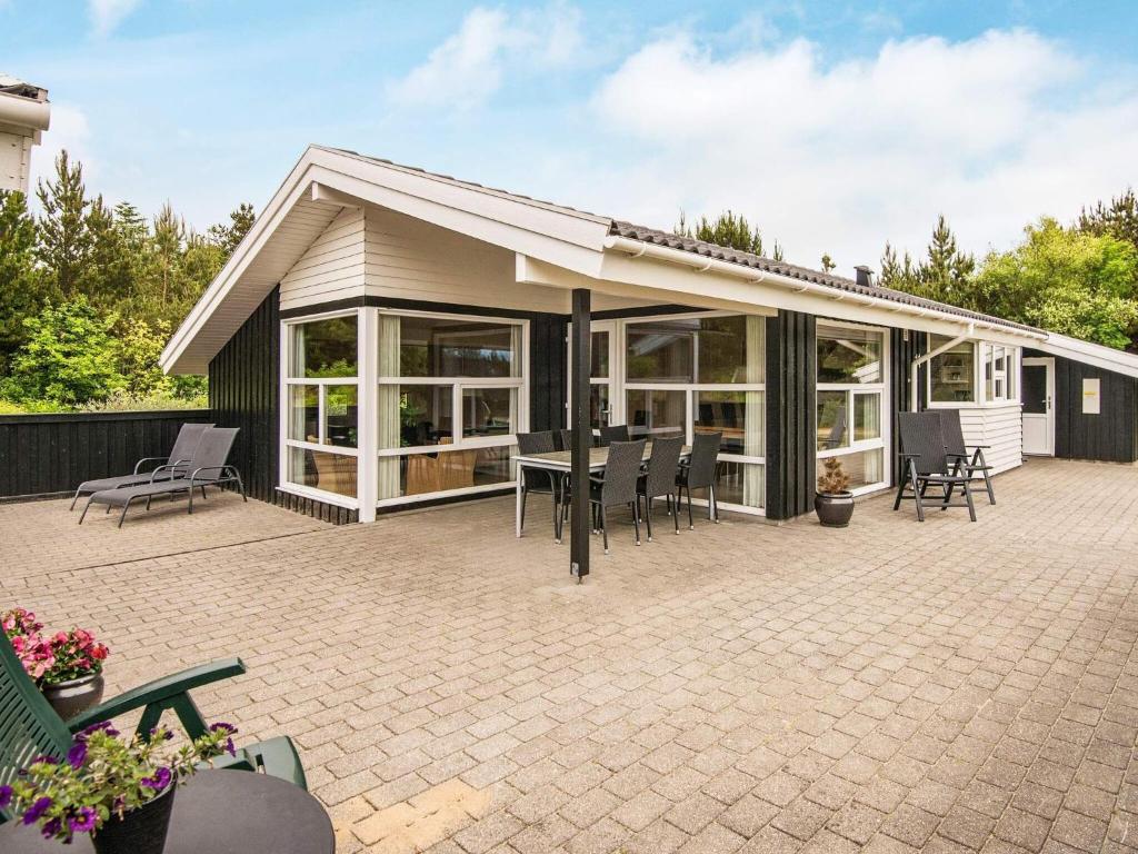 a house with a patio with a table and chairs at 6 person holiday home in Henne in Henne Strand