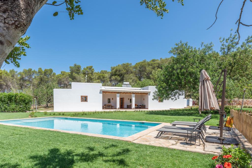 eine Villa mit einem Pool und einem Haus in der Unterkunft Casa rural es Murtà in Santa Eulària des Riu