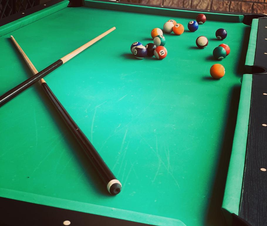 a green pool table with billiard balls and cues at Casa Vacanze Belvedere in Partinico