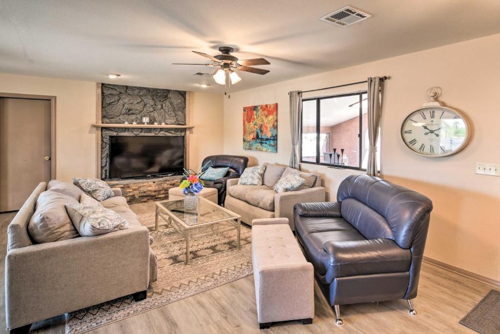 a living room with couches and a fireplace and a clock at Homey Lake Havasu Abode An Ideal Boaters Getaway! in Lake Havasu City