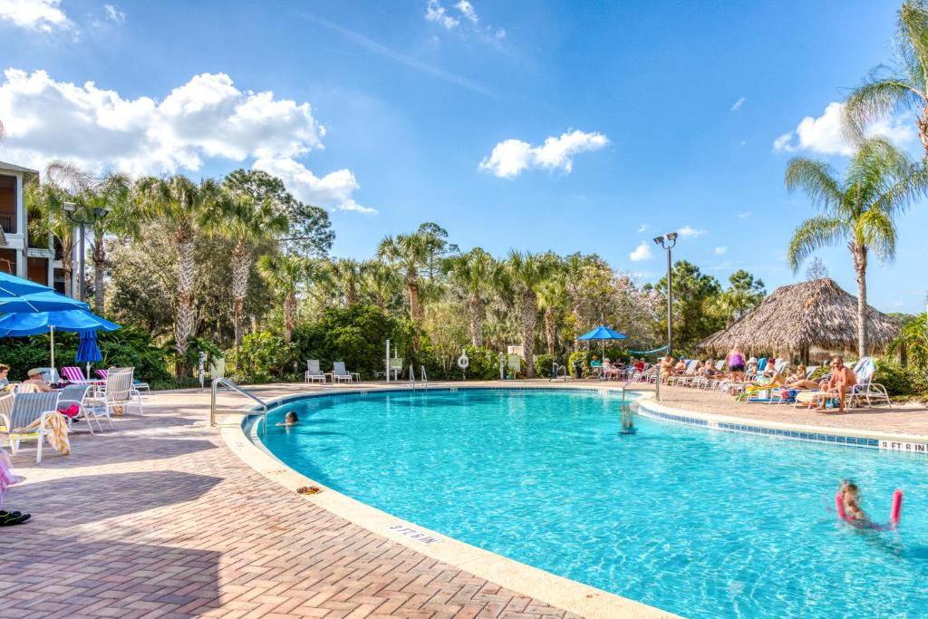 una piscina en un complejo con gente sentada alrededor en Bahama Bay Resort, en Kissimmee