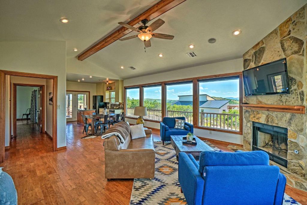 a living room with a fireplace and a stone wall at Updated Cabin with 360-Degree Mtn View 1 Mi to Lake in Medicine Park