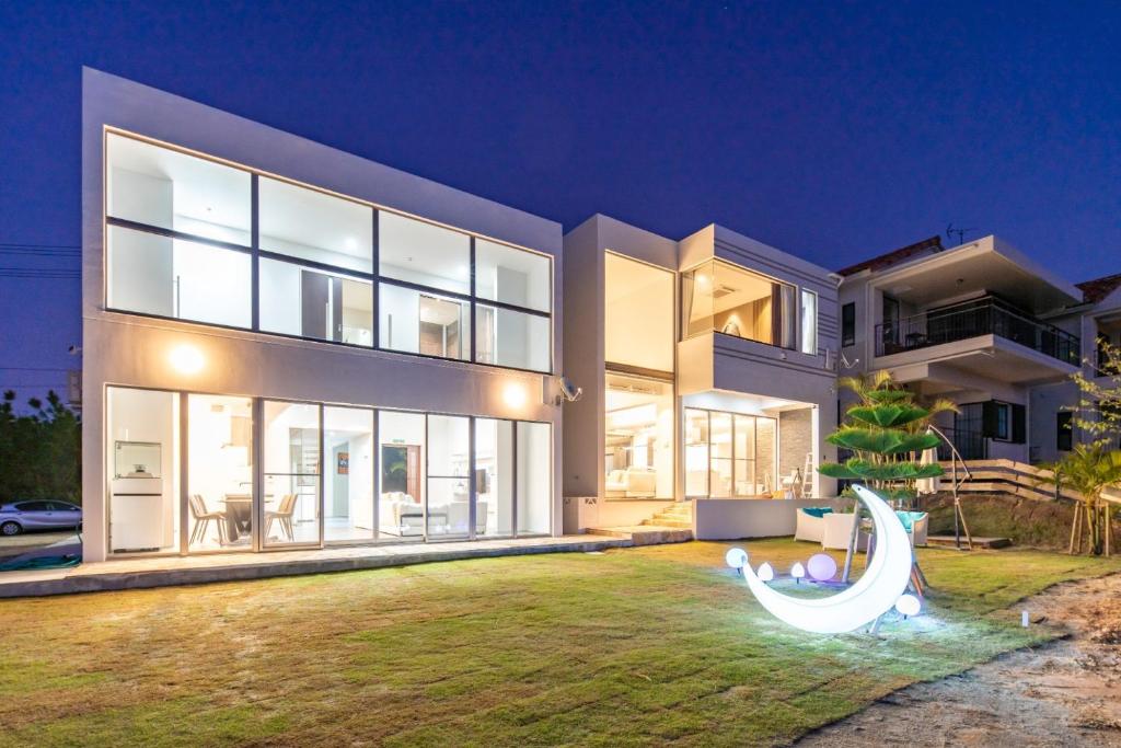 uma casa grande com escorrega no quintal em Ocean Villa Fuchaku Okinawa / Vacation STAY 79452 em Onna