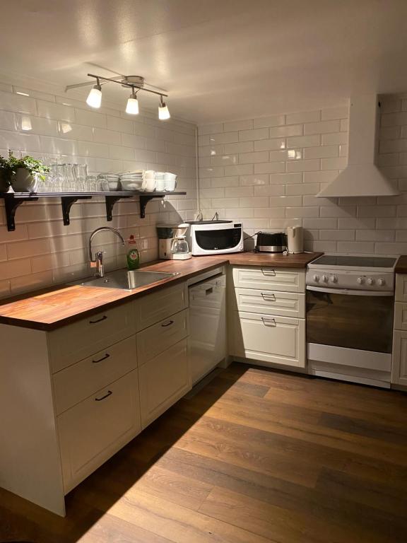 a kitchen with a sink and a microwave at Yxefall Norrgården in Kisa