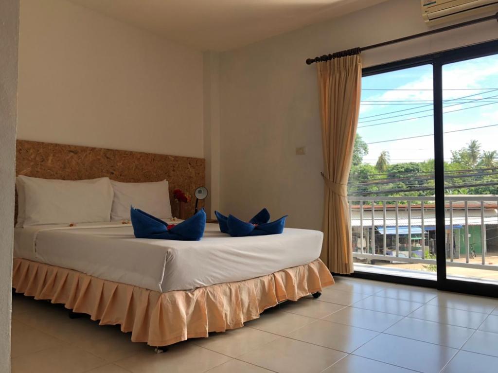 a bedroom with a large bed with blue pillows on it at Baan Anattaya Koh yao noi in Ko Yao Noi