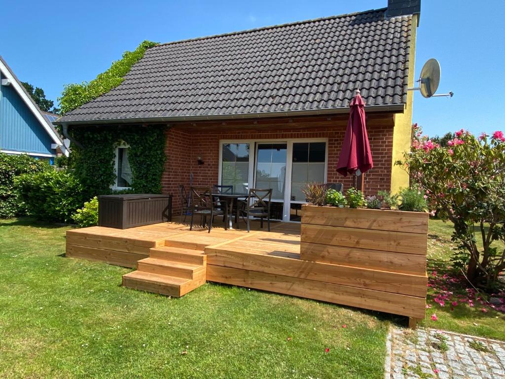 einen Hinterhof mit einer Holzterrasse mit einem Tisch und Stühlen in der Unterkunft Haus Meere´s Stille in Zingst