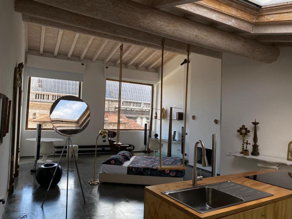 Zimmer mit einem Bett und einer Küche mit einem Waschbecken in der Unterkunft SPIRIT of the MOON in Brescia