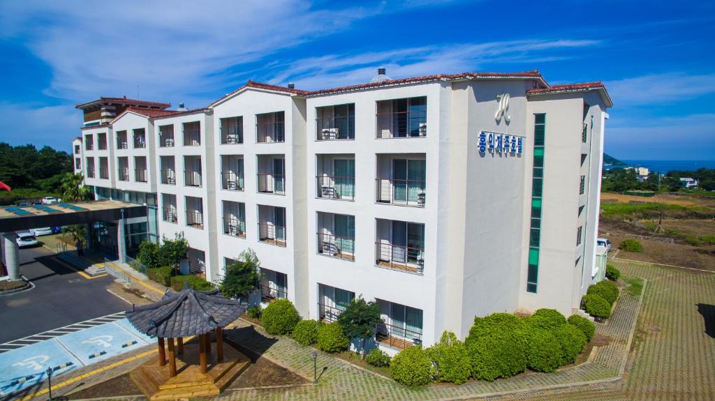 an aerial view of a white building with a pool at Hi Jeju Hotel in Jeju