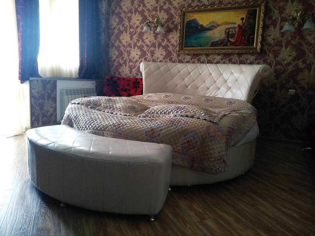 1 dormitorio con cama blanca y reposapiés blanco en Hotel Edemi Castle, en Kutaisi