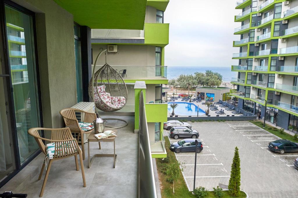 uma varanda com cadeiras e vista para um parque de estacionamento em Sea la Vie 2BR Apt Spa n Pool Beach resort em Mamaia Nord – Năvodari