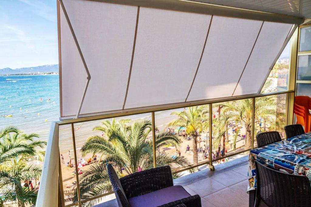 a room with a balcony with a view of the beach at Comfortable seaside apartment in Salou - 85 m² - Sea view in Salou
