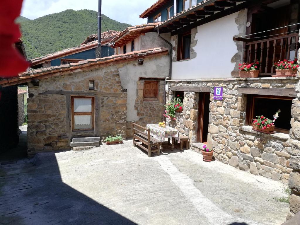 a stone house with a table in front of it at LA CASUCA Y LA CABAÑA in Ojedo