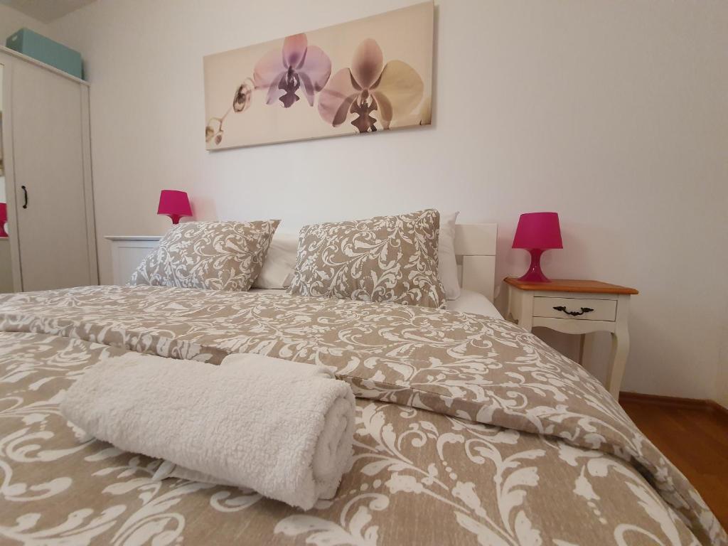 a bedroom with a bed with a gray and white comforter at Apartman Nikolina in Biograd na Moru