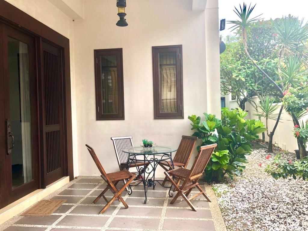 a patio with a table and chairs in front of a house at Tropical Home in George Town