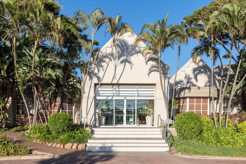 un edificio con palmeras delante en City Lodge Hotel Durban, en Durban