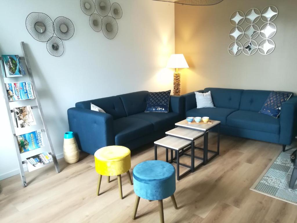 un salon avec un canapé bleu et une table dans l'établissement Le gîte Donemat, à Ploudalmézeau
