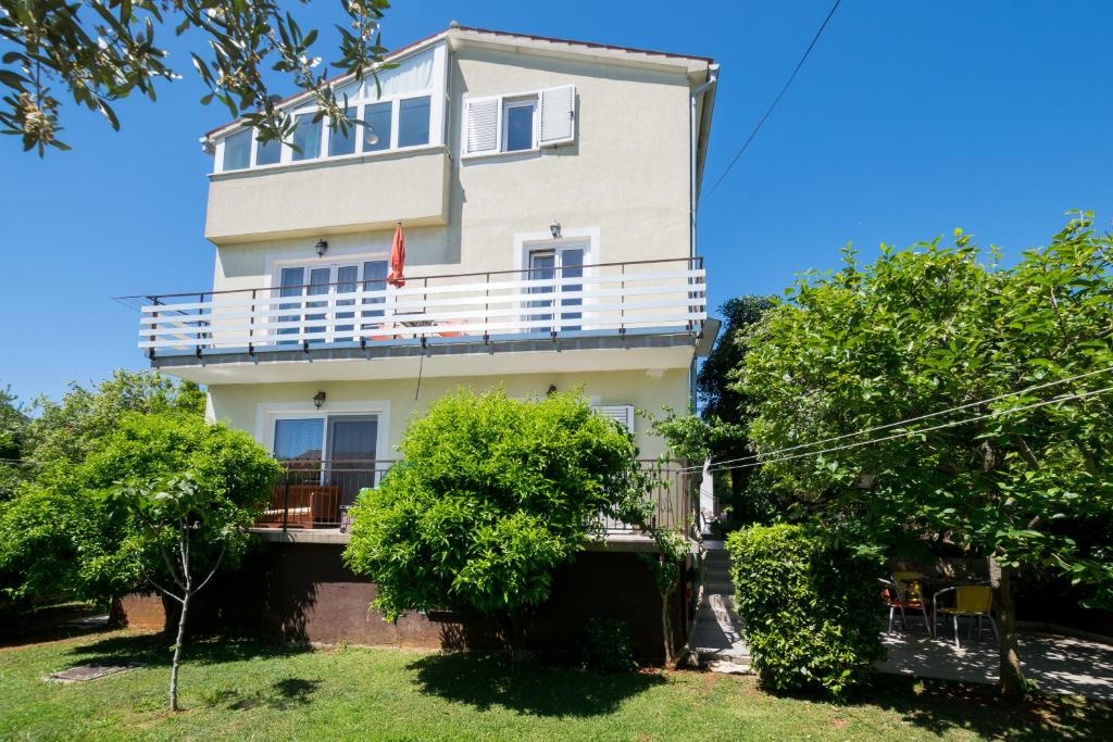 duży biały budynek z drzewami przed nim w obiekcie Cozy apartments Emina near the sea w mieście Premantura