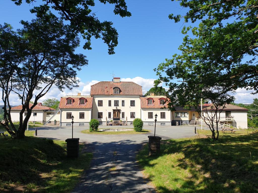 ein großes weißes Gebäude mit rotem Dach in der Unterkunft Tokeryds Herrgård in Jönköping