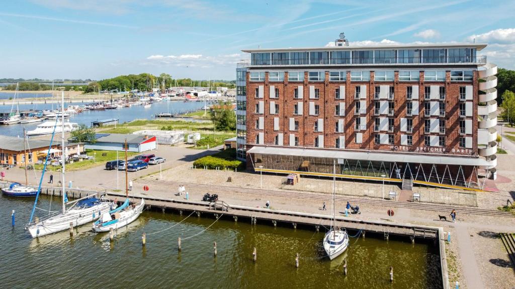 a building next to a marina with boats in the water at Speicher Barth - Superior-Hotel in Barth