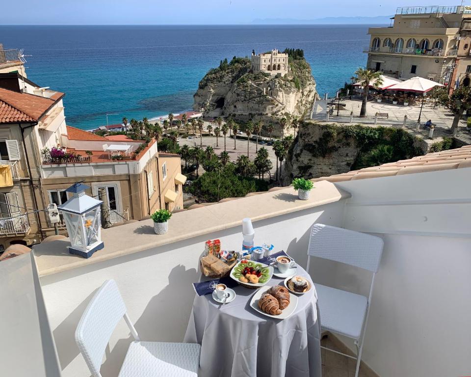 uma mesa com comida numa varanda com vista para o oceano em B&B Island Vista mare em Tropea