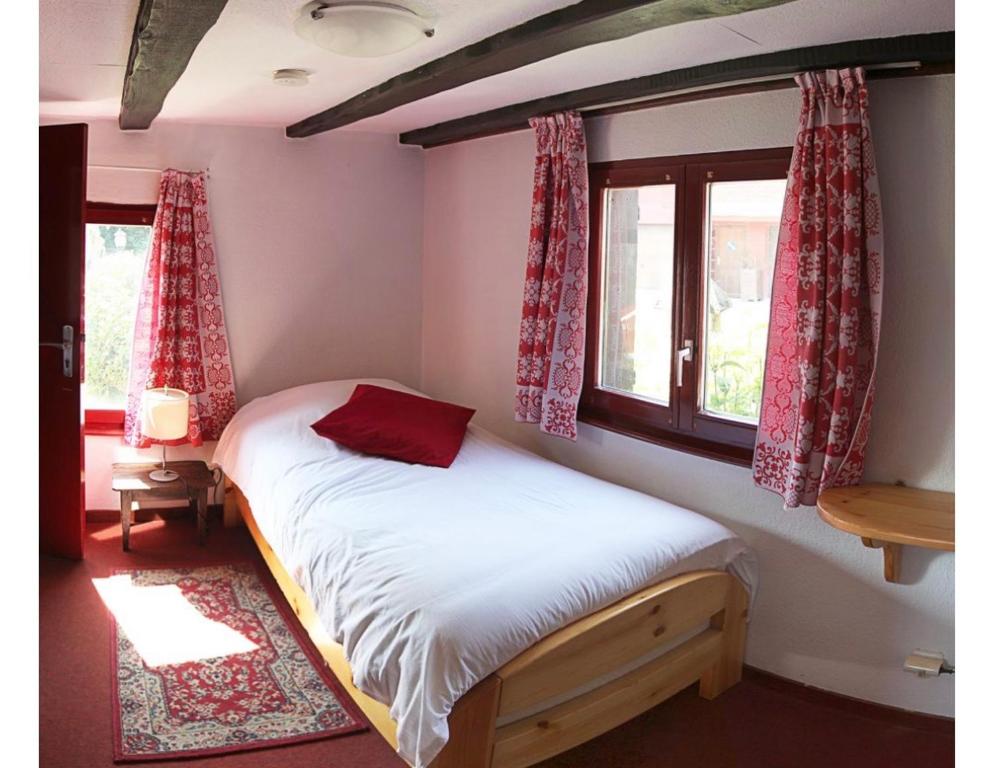 a small bedroom with a bed and a window at Auberge du Tisserand in Gommersdorf