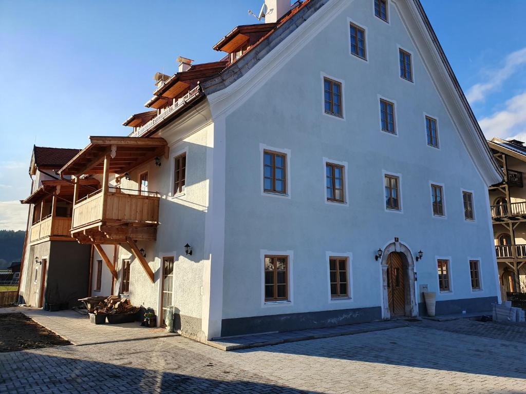 a white building with a balcony on the side of it at Flösserhaus - Kirchbichl Top 3 in Kirchbichl