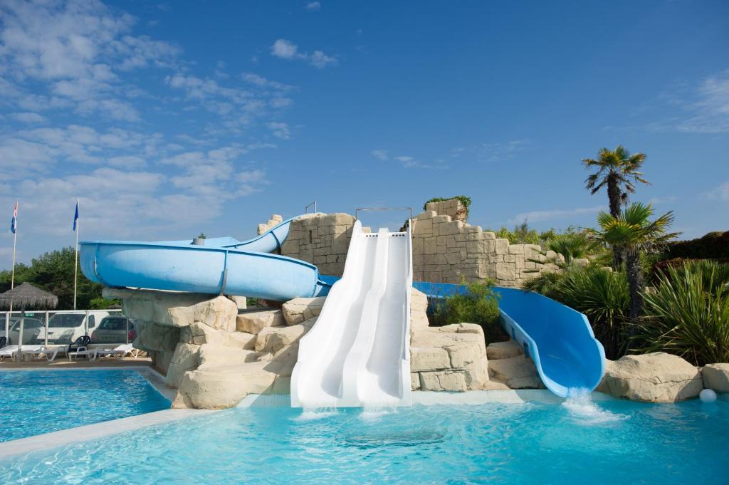 a water slide in a pool at a resort at Mobile Homes by KelAir at Camping Sol a Go Go in Saint-Hilaire-de-Riez