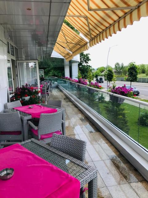 a restaurant with pink tables and chairs on a balcony at Hotel Afrodita -Valenii De Munte in Vălenii de Munte
