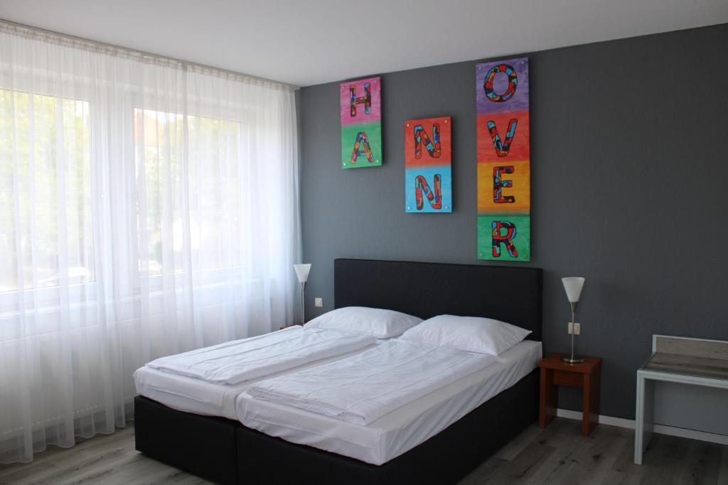sypialnia z dużym łóżkiem z białą pościelą w obiekcie Plaza Inn Hannover City Nord w Hanowerze