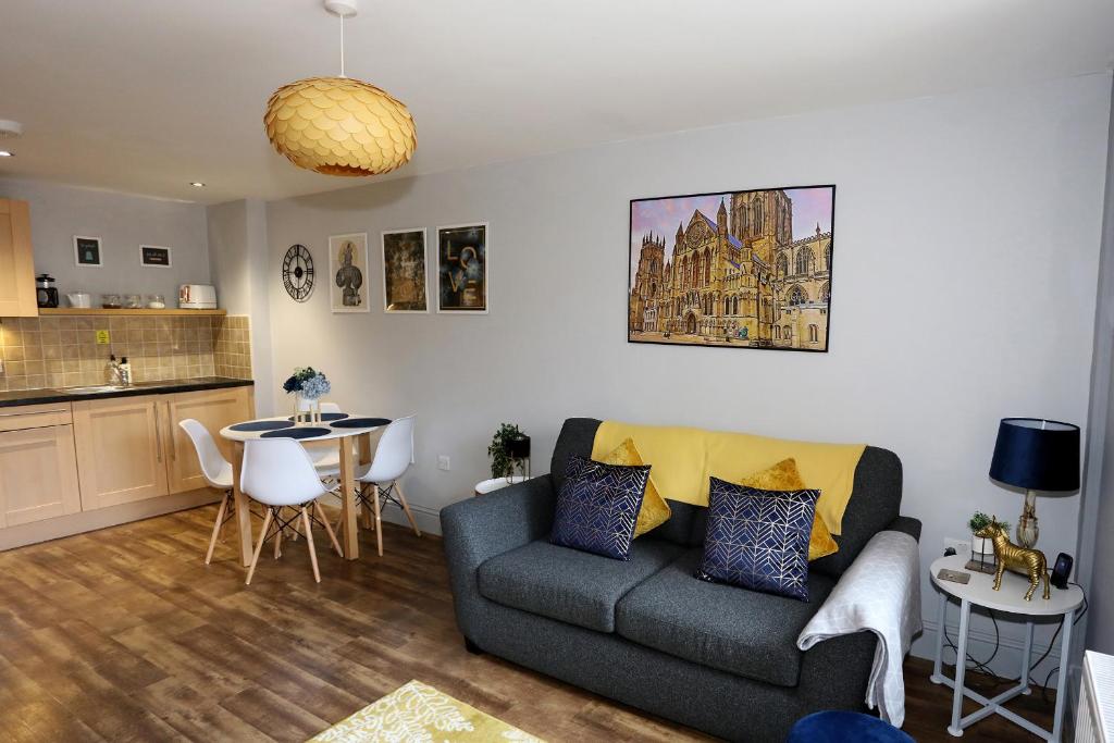 a living room with a couch and a table at Private George Hudson Court Apartments close to city walls in York
