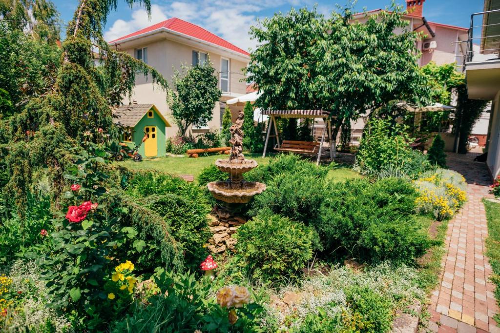 a garden with a fountain in the middle of a yard at Guest house VadLen in Odesa