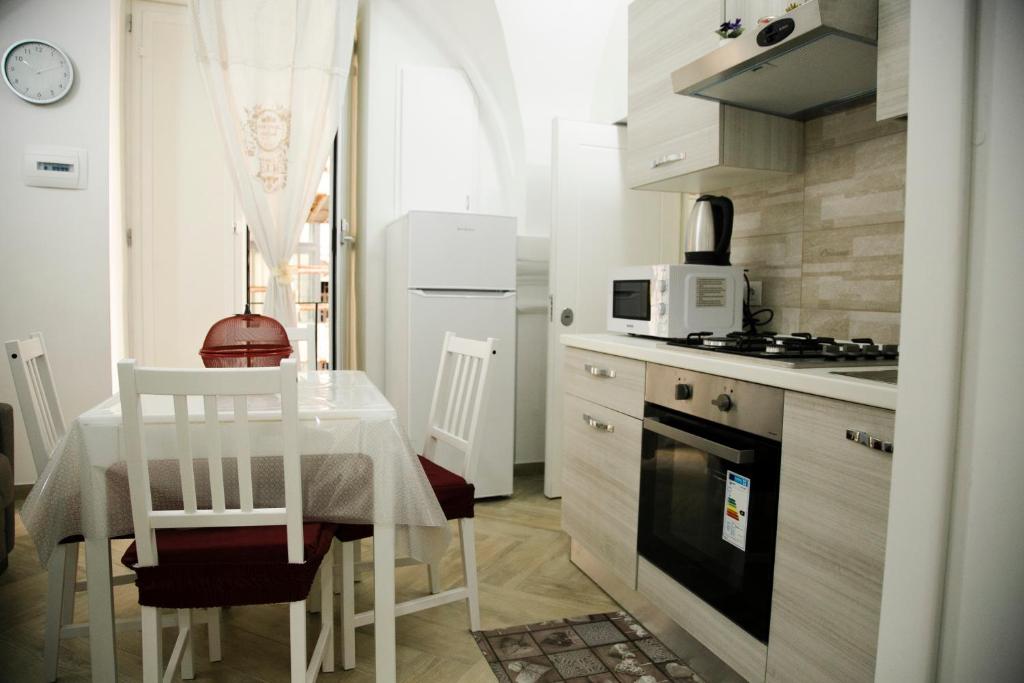 une petite cuisine avec une table et une table et des chaises blanches dans l'établissement Appartament Peppino Home, à Naples