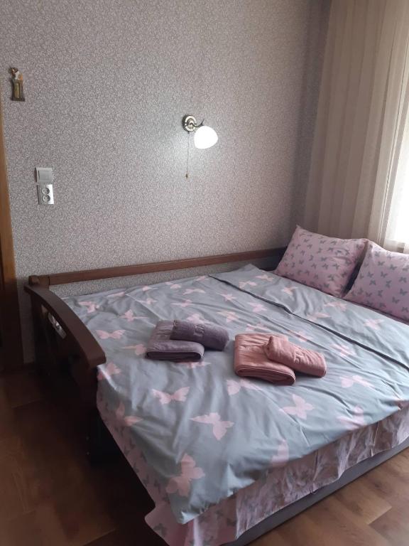 a bedroom with a bed with two pillows on it at Однокімнатна in Shepetivka