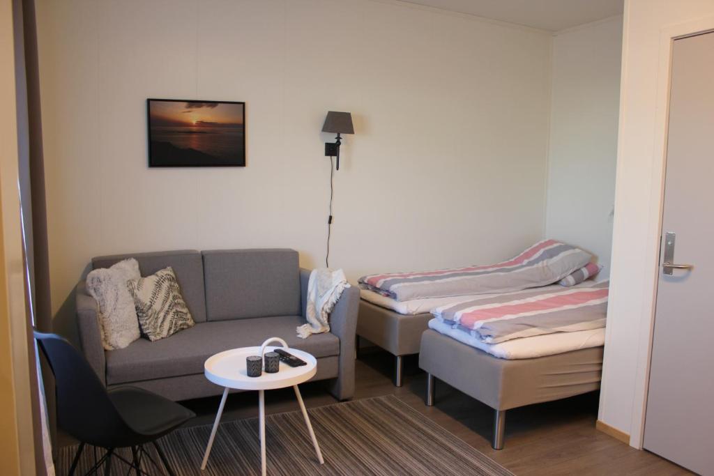Habitación con 2 camas, sofá y mesa. en Joker Bø, en Bø i Vesterålen